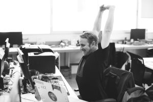 Man Stretching Arms during Break Time at Workplace